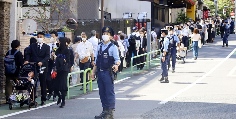 Pemakaman kenegaraan mantan Perdana Menteri Jepang Shinzo Abe Orang-orang meninggalkan bunga dan memberi penghormatan kepada mantan Perdana Menteri Jepang Shinzo Abe di luar Nippon Budokan di Tokyo, Jepang Selasa (27/9/2022). Diperkirakan 4.300 orang akan menghadiri seremoni pemakaman kenegaraan ini, dengan sedikitnya 48 pemimpin atau pejabat tinggi pemerintahan berbagai negara, baik yang masih aktif menjabat maupun yang sudah tidak menjabat, akan turut hadir. (Nicolas Datiche/Pool Photo via AP)