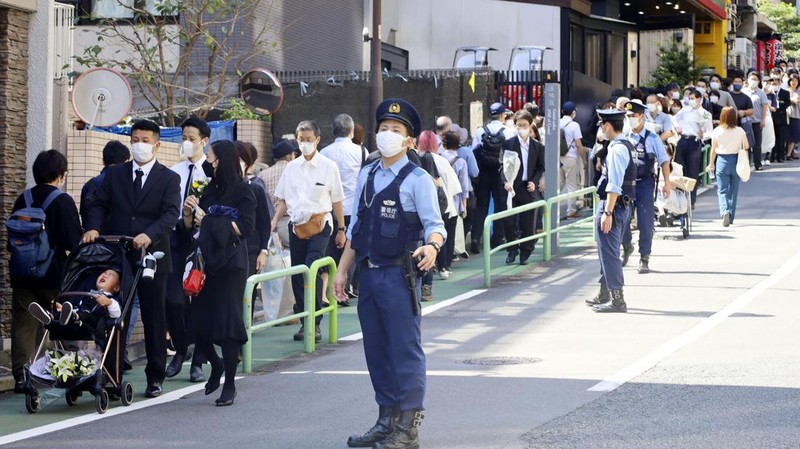Orang-orang meninggalkan bunga dan memberi penghormatan kepada mantan Perdana Menteri Jepang Shinzo Abe di luar Nippon Budokan di Tokyo, Jepang Selasa (27/9/2022). Diperkirakan 4.300 orang akan menghadiri seremoni pemakaman kenegaraan ini, dengan sedikitnya 48 pemimpin atau pejabat tinggi pemerintahan berbagai negara, baik yang masih aktif menjabat maupun yang sudah tidak menjabat, akan turut hadir. (Nicolas Datiche/Pool Photo via AP)