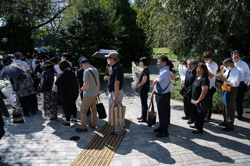 Pemakaman kenegaraan mantan Perdana Menteri Jepang Shinzo Abe Orang-orang meninggalkan bunga dan memberi penghormatan kepada mantan Perdana Menteri Jepang Shinzo Abe di luar Nippon Budokan di Tokyo, Jepang Selasa (27/9/2022). Diperkirakan 4.300 orang akan menghadiri seremoni pemakaman kenegaraan ini, dengan sedikitnya 48 pemimpin atau pejabat tinggi pemerintahan berbagai negara, baik yang masih aktif menjabat maupun yang sudah tidak menjabat, akan turut hadir. (Nicolas Datiche/Pool Photo via AP)