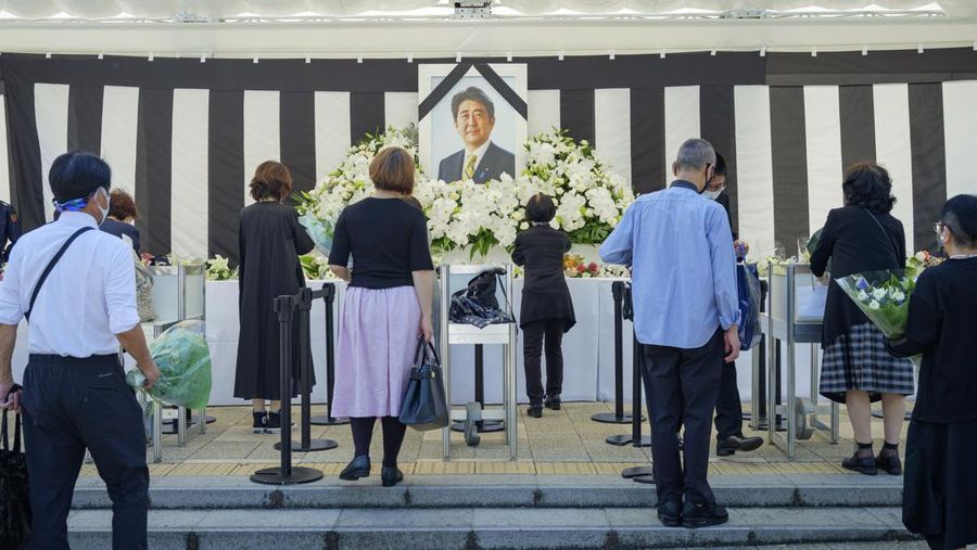 Orang-orang meninggalkan bunga dan memberi penghormatan kepada mantan Perdana Menteri Jepang Shinzo Abe di luar Nippon Budokan di Tokyo, Jepang Selasa (27/9/2022). Diperkirakan 4.300 orang akan menghadiri seremoni pemakaman kenegaraan ini, dengan sedikitnya 48 pemimpin atau pejabat tinggi pemerintahan berbagai negara, baik yang masih aktif menjabat maupun yang sudah tidak menjabat, akan turut hadir. (Nicolas Datiche/Pool Photo via AP)