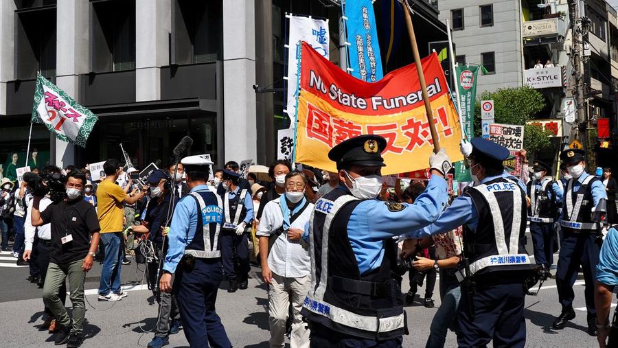 Orang-orang meninggalkan bunga dan memberi penghormatan kepada mantan Perdana Menteri Jepang Shinzo Abe di luar Nippon Budokan di Tokyo, Jepang Selasa (27/9/2022). Diperkirakan 4.300 orang akan menghadiri seremoni pemakaman kenegaraan ini, dengan sedikitnya 48 pemimpin atau pejabat tinggi pemerintahan berbagai negara, baik yang masih aktif menjabat maupun yang sudah tidak menjabat, akan turut hadir. (Nicolas Datiche/Pool Photo via AP)