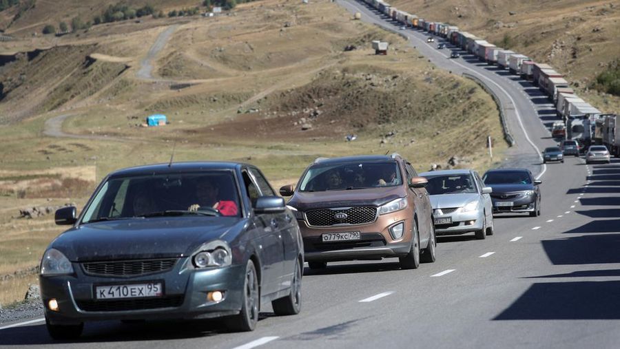 Sejumlah warga Rusia berjalan setelah melintasi perbatasan di Verkhny Lars antara Georgia dan Rusia di Georgia, Selasa (27/9/2022). Mereka keluar dari negaranya untuk menghindari dipanggil untuk ikut dalam perang di Ukraina yang tidak mereka setujui. (AP Photo/Zurab Tsertsvadze)