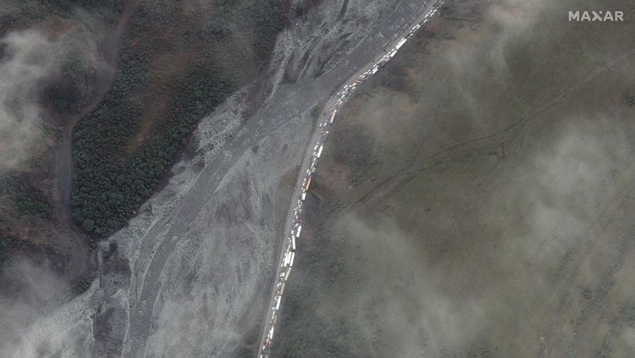 Sejumlah warga Rusia berjalan setelah melintasi perbatasan di Verkhny Lars antara Georgia dan Rusia di Georgia, Selasa (27/9/2022). Mereka keluar dari negaranya untuk menghindari dipanggil untuk ikut dalam perang di Ukraina yang tidak mereka setujui. (AP Photo/Zurab Tsertsvadze)