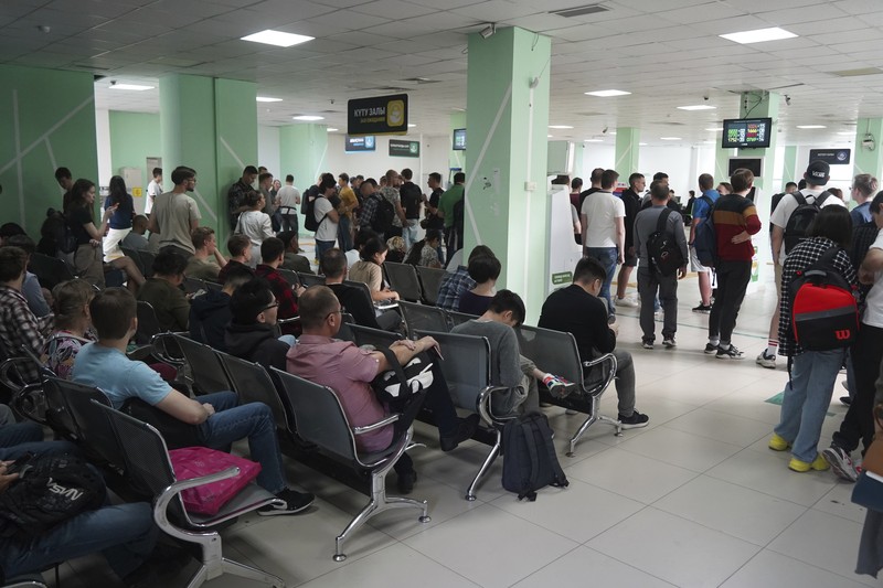 Sejumlah warga Rusia berjalan setelah melintasi perbatasan di Verkhny Lars antara Georgia dan Rusia di Georgia, Selasa (27/9/2022). Mereka keluar dari negaranya untuk menghindari dipanggil untuk ikut dalam perang di Ukraina yang tidak mereka setujui. (AP Photo/Zurab Tsertsvadze)