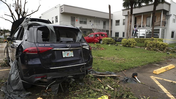 Mobil rusak akibat tornado semalam yang muncul dari Badai Ian di komunitas Kings Point 55+ di Delray Beach, Florida, AS, Rabu (28/9/2022). Badai dengan kategori 4 ini memiliki kecepatan angin maksimum 150 mil per jam (240 kilometer per jam) ketika mendarat dan sudah menyebabkan gelombang badai bencana, angin dan banjir di semenanjung Florida. (Carline Jean/South Florida Sun-Sentinel via AP)
