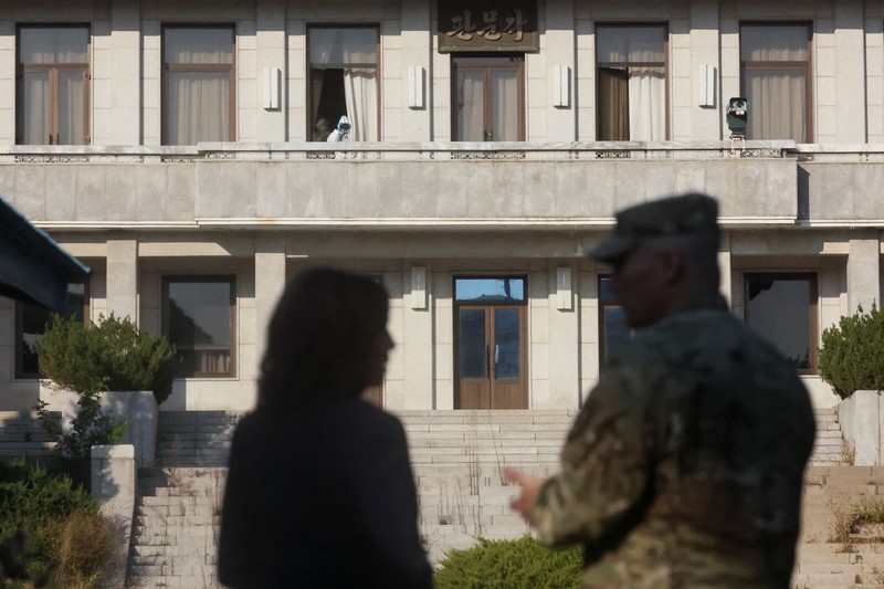 Seorang tentara di wilayah Korea Utara melihat melalui teropong saat Wakil Presiden AS Kamala Harris mengunjungi zona demiliterisasi (DMZ) yang memisahkan kedua Korea, di Panmunjom, Korea Selatan, Kamis (29/9/2022). Sebelum ke DMZ, Harris bertemu dengan Presiden Korsel, Yoon Seok Yeol. Dalam pertemuan ini, ia menegaskan soal penguatan kerja sama dan hubungan kedua negara. (REUTERS/Leah Millis/Pool)
