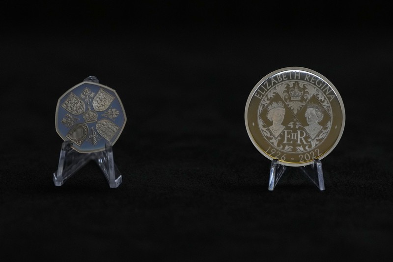 Two new coins bearing official coinage portrait of King Charles III, on the left is the new 50 pence coin, and right is the new 5 pound commemorative coin, which will be among the first coins to bear the new king's head, during a press preview in London, Thursday, Sept. 29, 2022. The likeness of the king was created by British sculptor Martin Jennings, and approved by the king. (AP Photo/Alastair Grant)