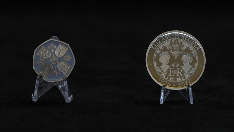 Two new coins bearing official coinage portrait of King Charles III, on the left is the new 50 pence coin, and right is the new 5 pound commemorative coin, which will be among the first coins to bear the new king's head, during a press preview in London, Thursday, Sept. 29, 2022. The likeness of the king was created by British sculptor Martin Jennings, and approved by the king. (AP Photo/Alastair Grant)