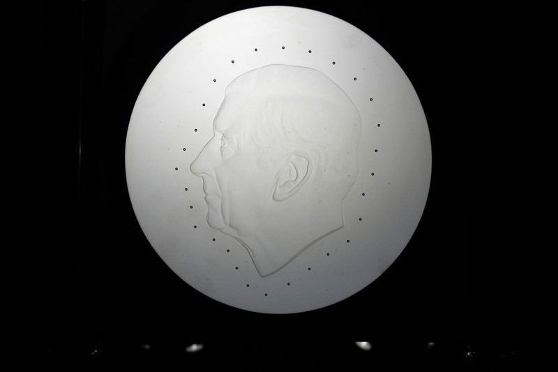 Two new coins bearing official coinage portrait of King Charles III, on the left is the new 50 pence coin, and right is the new 5 pound commemorative coin, which will be among the first coins to bear the new king's head, during a press preview in London, Thursday, Sept. 29, 2022. The likeness of the king was created by British sculptor Martin Jennings, and approved by the king. (AP Photo/Alastair Grant)