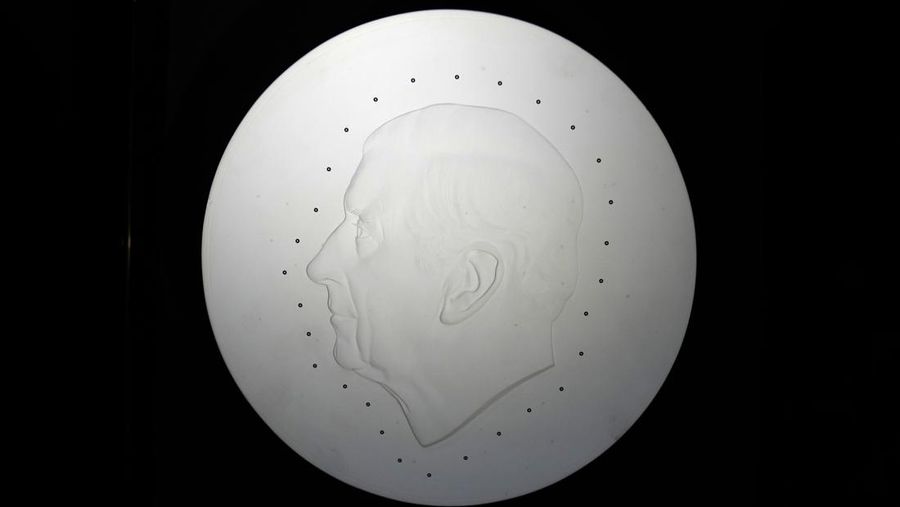Two new coins bearing official coinage portrait of King Charles III, on the left is the new 50 pence coin, and right is the new 5 pound commemorative coin, which will be among the first coins to bear the new king's head, during a press preview in London, Thursday, Sept. 29, 2022. The likeness of the king was created by British sculptor Martin Jennings, and approved by the king. (AP Photo/Alastair Grant)