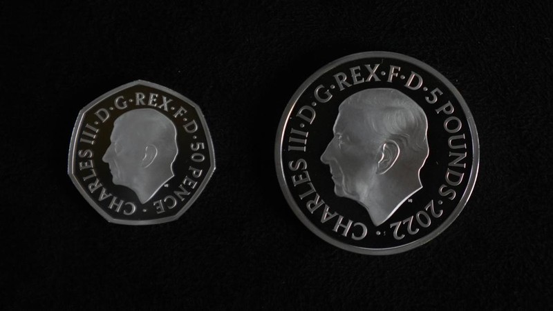 Two new coins bearing official coinage portrait of King Charles III, on the left is the new 50 pence coin, and right is the new 5 pound commemorative coin, which will be among the first coins to bear the new king's head, during a press preview in London, Thursday, Sept. 29, 2022. The likeness of the king was created by British sculptor Martin Jennings, and approved by the king. (AP Photo/Alastair Grant)