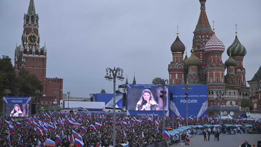 People wave Russian national flags as they gather during celebrations marking the annexation of the Luhansk region into Russia in Luhansk, Ukraine, Friday, Sept. 30, 2022. The signing of the treaties making the four annexed regions part of Russia follows the completion of the Kremlin-orchestrated 