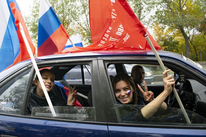 Russia Ukraine People wave Russian national flags as they gather during celebrations marking the annexation of the Luhansk region into Russia in Luhansk, Ukraine, Friday, Sept. 30, 2022. The signing of the treaties making the four annexed regions part of Russia follows the completion of the Kremlin-orchestrated