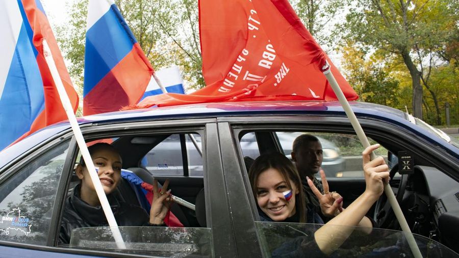 People wave Russian national flags as they gather during celebrations marking the annexation of the Luhansk region into Russia in Luhansk, Ukraine, Friday, Sept. 30, 2022. The signing of the treaties making the four annexed regions part of Russia follows the completion of the Kremlin-orchestrated 