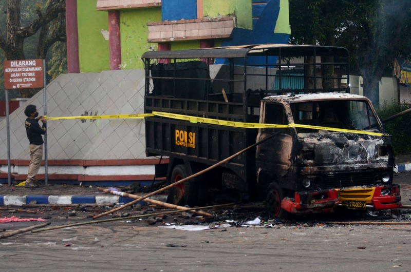 This picture taken on October 1, 2022 shows security personnel (lower) on the pitch after a football match between Arema FC and Persebaya Surabaya at Kanjuruhan stadium in Malang, East Java. - At least 127 people died at a football stadium in Indonesia late on October 1 when fans invaded the pitch and police responded with tear gas, triggering a stampede, officials said. (Photo by AFP) (Photo by STR/AFP via Getty Images)