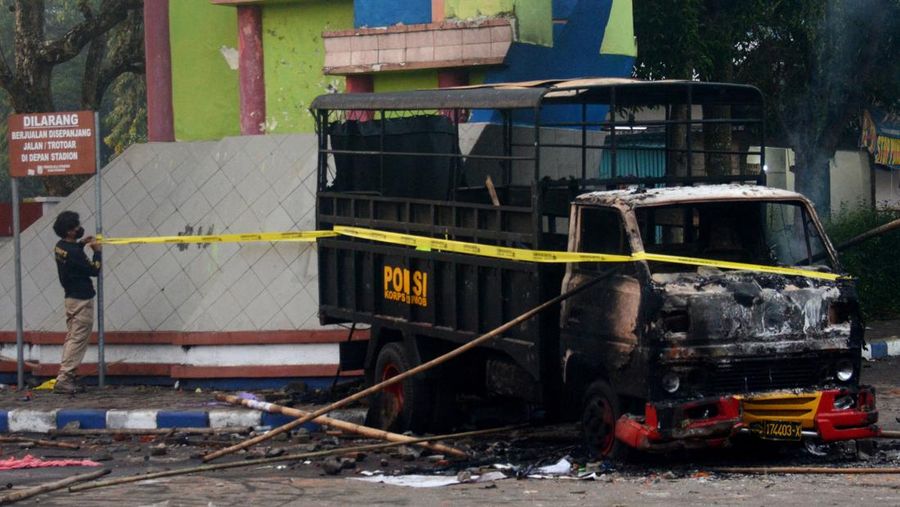 This picture taken on October 1, 2022 shows security personnel (lower) on the pitch after a football match between Arema FC and Persebaya Surabaya at Kanjuruhan stadium in Malang, East Java. - At least 127 people died at a football stadium in Indonesia late on October 1 when fans invaded the pitch and police responded with tear gas, triggering a stampede, officials said. (Photo by AFP) (Photo by STR/AFP via Getty Images)