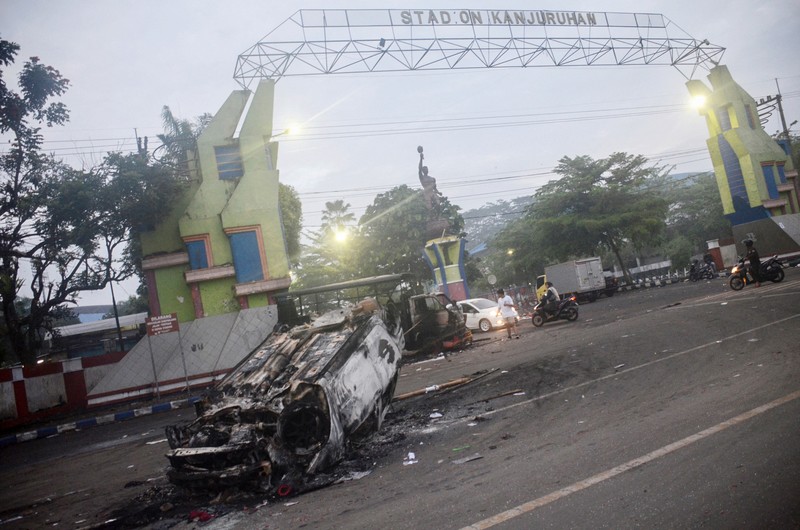 This picture taken on October 1, 2022 shows security personnel (lower) on the pitch after a football match between Arema FC and Persebaya Surabaya at Kanjuruhan stadium in Malang, East Java. - At least 127 people died at a football stadium in Indonesia late on October 1 when fans invaded the pitch and police responded with tear gas, triggering a stampede, officials said. (Photo by AFP) (Photo by STR/AFP via Getty Images)