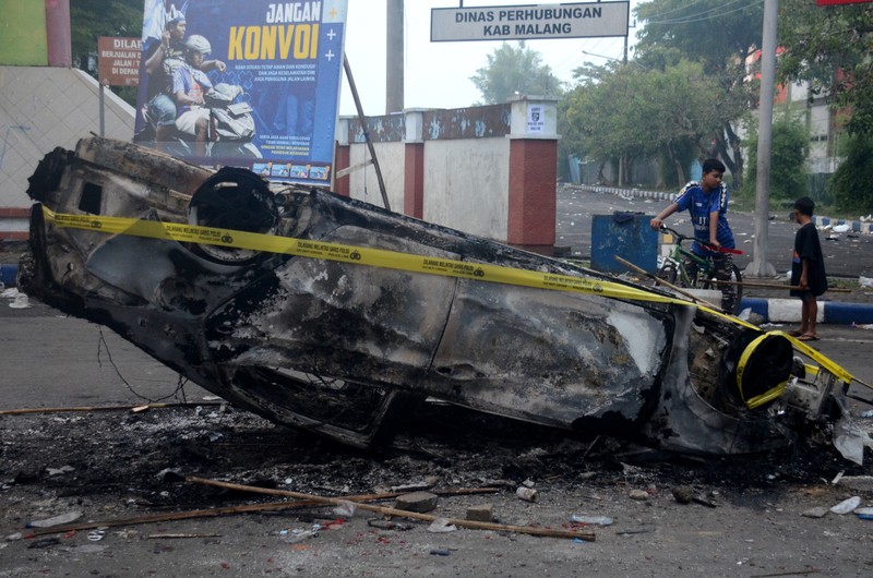 This picture taken on October 1, 2022 shows security personnel (lower) on the pitch after a football match between Arema FC and Persebaya Surabaya at Kanjuruhan stadium in Malang, East Java. - At least 127 people died at a football stadium in Indonesia late on October 1 when fans invaded the pitch and police responded with tear gas, triggering a stampede, officials said. (Photo by AFP) (Photo by STR/AFP via Getty Images)