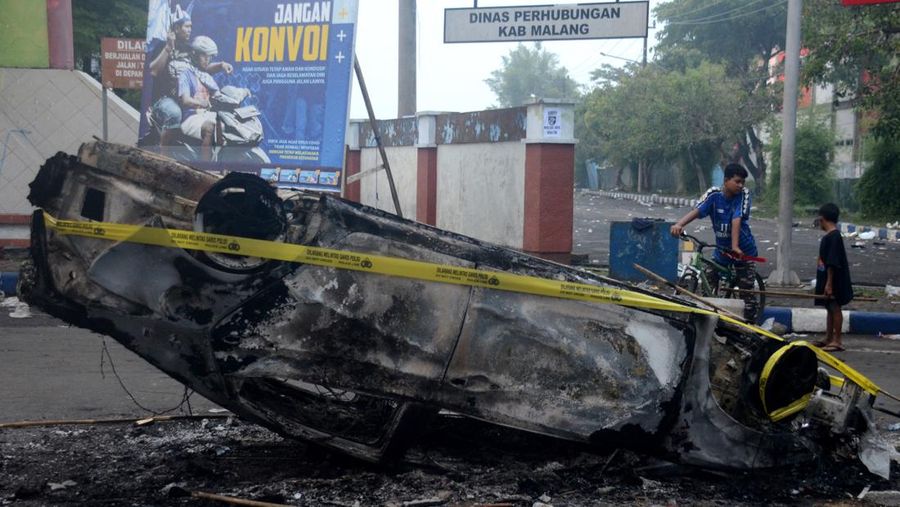 This picture taken on October 1, 2022 shows security personnel (lower) on the pitch after a football match between Arema FC and Persebaya Surabaya at Kanjuruhan stadium in Malang, East Java. - At least 127 people died at a football stadium in Indonesia late on October 1 when fans invaded the pitch and police responded with tear gas, triggering a stampede, officials said. (Photo by AFP) (Photo by STR/AFP via Getty Images)