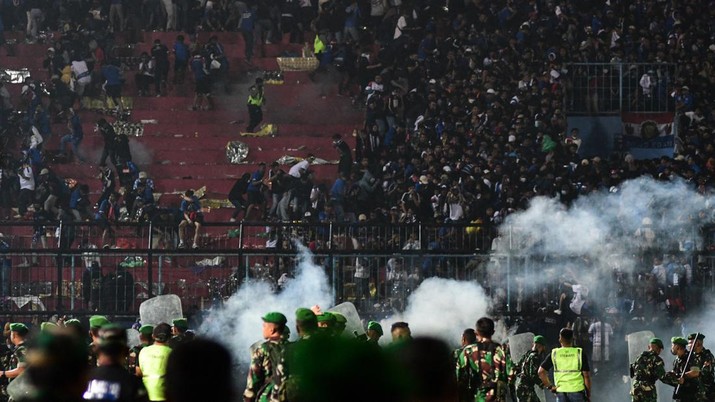 1243656840 This picture taken on October 1, 2022 shows security personnel (lower) on the pitch after a football match between Arema FC and Persebaya Surabaya at Kanjuruhan stadium in Malang, East Java. - At least 127 people died at a football stadium in Indonesia late on October 1 when fans invaded the pitch and police responded with tear gas, triggering a stampede, officials said. (Photo by AFP) (Photo by STR/AFP via Getty Images)