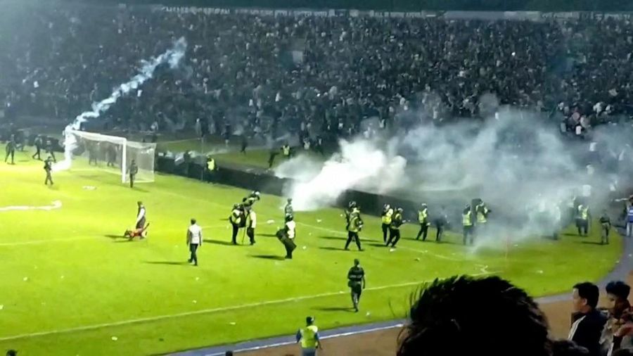 Anggota pasukan keamanan berusaha membubarkan para suporter yang menyerbu lapangan sepak bola usai pertandingan antara Arema FC dan Persebaya Surabaya di Stadion Kanjuruhan, Malang, Indonesia 2 Oktober 2022. (Reuters TV)