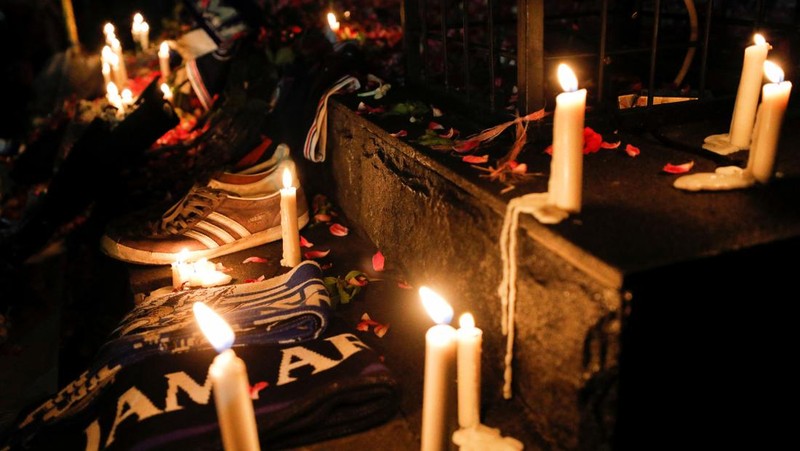 Arema football club supporters take part on a vigil outside the Kanjuruhan stadium to pay condolence to the victims, after a riot and stampede following soccer match between Arema vs Persebaya outside in Malang, East Java province, Indonesia, October 2, 2022. REUTERS/Willy Kurniawan