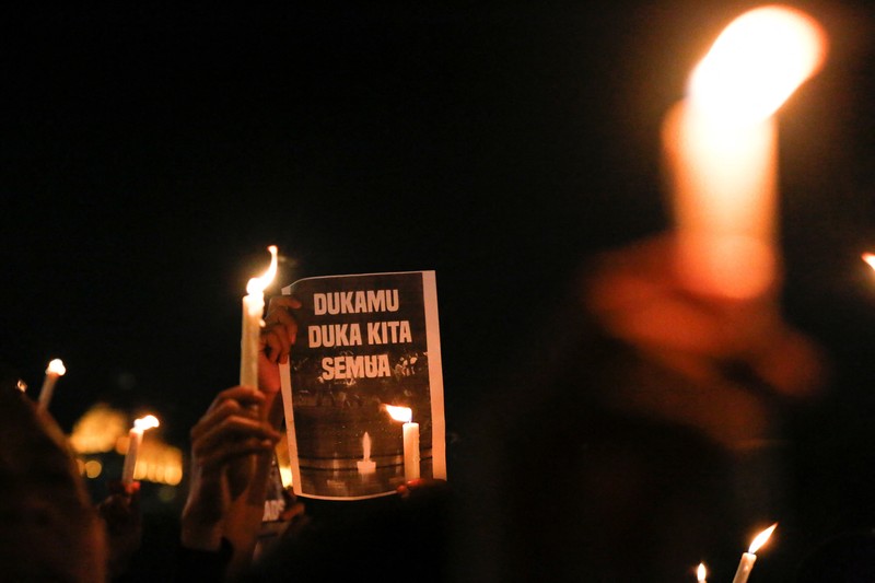 SOCCER-INDONESIA/RIOT Arema football club supporters take part on a vigil outside the Kanjuruhan stadium to pay condolence to the victims, after a riot and stampede following soccer match between Arema vs Persebaya outside in Malang, East Java province, Indonesia, October 2, 2022. REUTERS/Willy Kurniawan