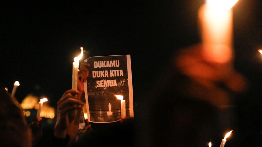 Arema football club supporters take part on a vigil outside the Kanjuruhan stadium to pay condolence to the victims, after a riot and stampede following soccer match between Arema vs Persebaya outside in Malang, East Java province, Indonesia, October 2, 2022. REUTERS/Willy Kurniawan