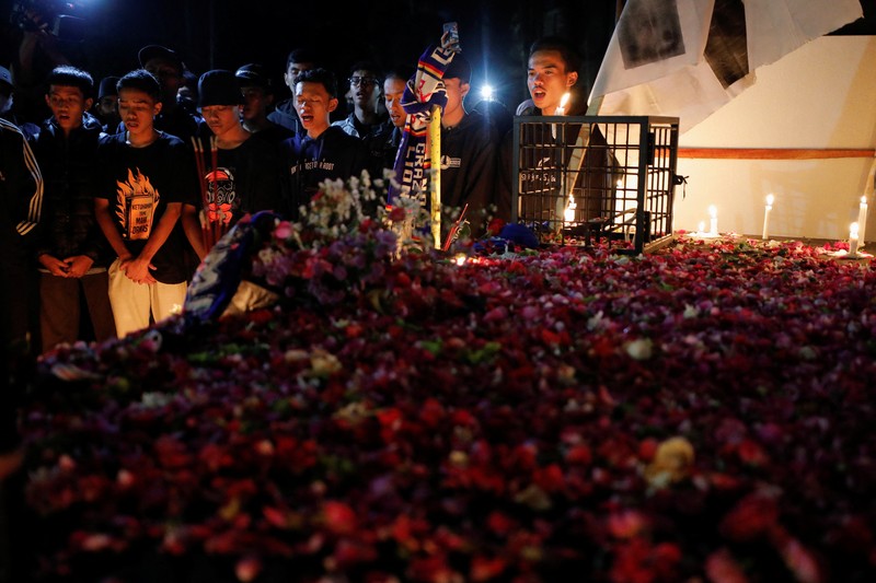 Arema football club supporters take part on a vigil outside the Kanjuruhan stadium to pay condolence to the victims, after a riot and stampede following soccer match between Arema vs Persebaya outside in Malang, East Java province, Indonesia, October 2, 2022. REUTERS/Willy Kurniawan