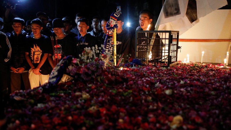 Arema football club supporters take part on a vigil outside the Kanjuruhan stadium to pay condolence to the victims, after a riot and stampede following soccer match between Arema vs Persebaya outside in Malang, East Java province, Indonesia, October 2, 2022. REUTERS/Willy Kurniawan