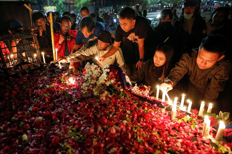 SOCCER-INDONESIA/RIOT Arema football club supporters take part on a vigil outside the Kanjuruhan stadium to pay condolence to the victims, after a riot and stampede following soccer match between Arema vs Persebaya outside in Malang, East Java province, Indonesia, October 2, 2022. REUTERS/Willy Kurniawan