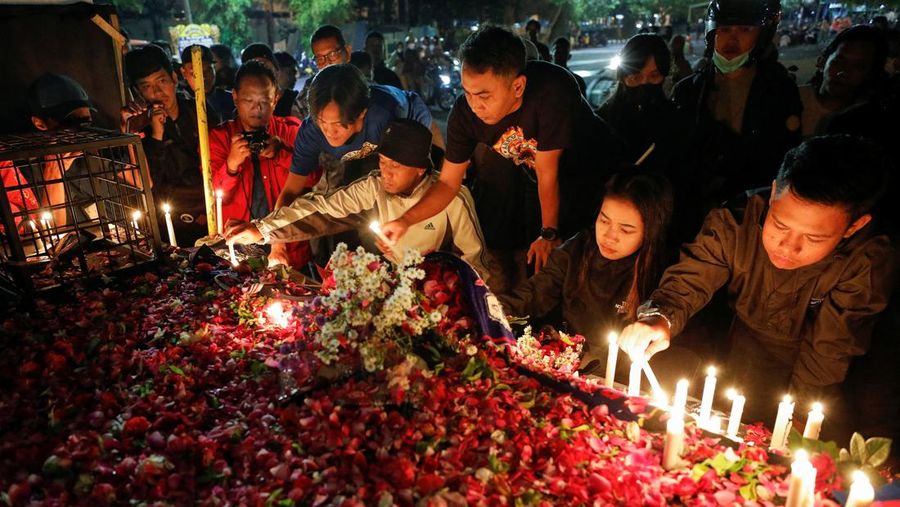 Arema football club supporters take part on a vigil outside the Kanjuruhan stadium to pay condolence to the victims, after a riot and stampede following soccer match between Arema vs Persebaya outside in Malang, East Java province, Indonesia, October 2, 2022. REUTERS/Willy Kurniawan
