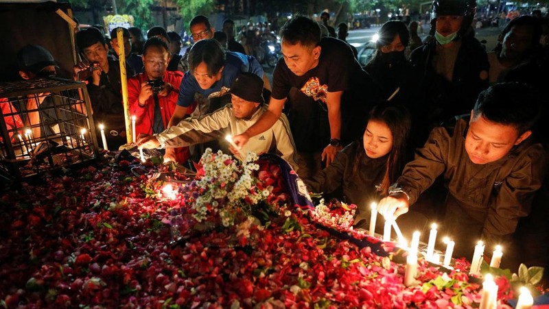 Arema football club supporters take part on a vigil outside the Kanjuruhan stadium to pay condolence to the victims, after a riot and stampede following soccer match between Arema vs Persebaya outside in Malang, East Java province, Indonesia, October 2, 2022. REUTERS/Willy Kurniawan