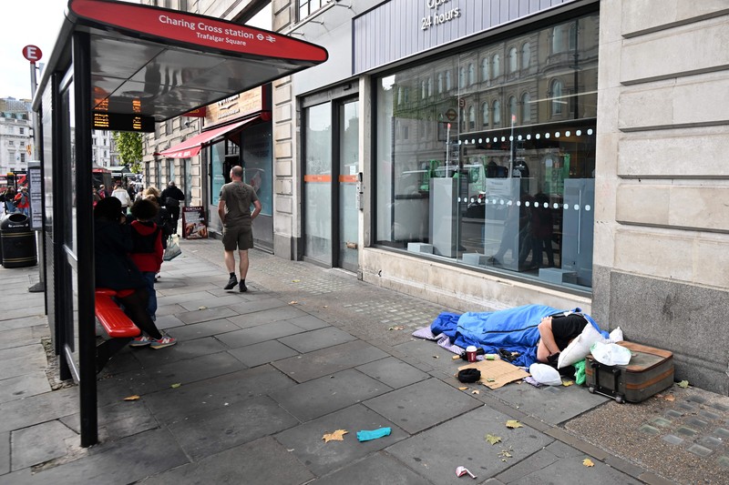 1243639948 A homeless man sleeps in his sleeping bag on The Strand in central London on October 1, 2022, as campaigners gather in the city to protest against the cost of living crisis. (Photo by JUSTIN TALLIS / AFP) (Photo by JUSTIN TALLIS/AFP via Getty Images)