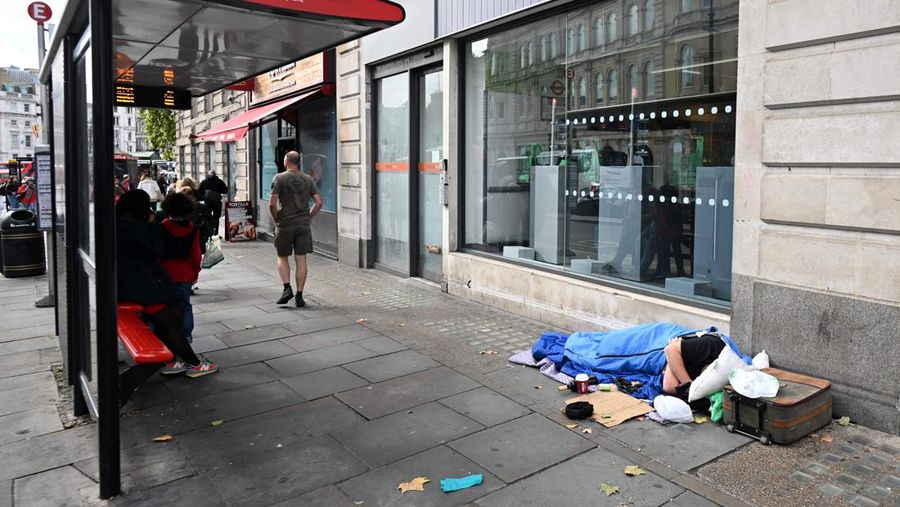 A homeless man sleeps in his sleeping bag on The Strand in central London on October 1, 2022, as campaigners gather in the city to protest against the cost of living crisis. (Photo by JUSTIN TALLIS / AFP) (Photo by JUSTIN TALLIS/AFP via Getty Images)