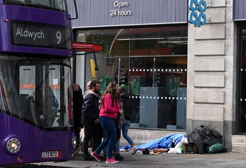 1243639948 A homeless man sleeps in his sleeping bag on The Strand in central London on October 1, 2022, as campaigners gather in the city to protest against the cost of living crisis. (Photo by JUSTIN TALLIS / AFP) (Photo by JUSTIN TALLIS/AFP via Getty Images)