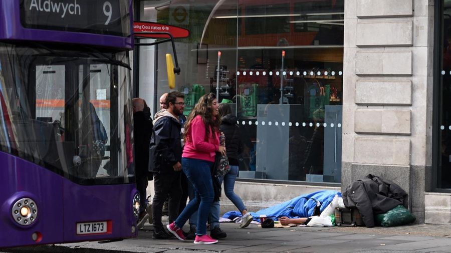 A homeless person sleeps in a sleeping bag on The Strand in central London on October 1, 2022, as campaigners gather in the city to protest against the cost of living crisis. (Photo by Justin TALLIS / AFP) (Photo by JUSTIN TALLIS/AFP via Getty Images)