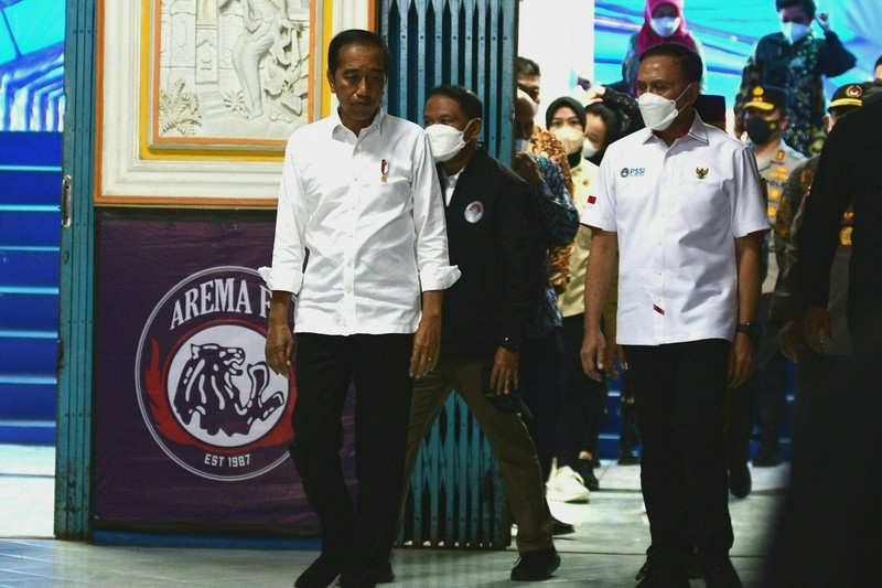 Indonesias President Joko Widodo (C) and Indonesia's Football Association of Indonesia (PSSI) chief Mochamad Iriawan (R) visit the Kanjuruhan stadium following a stampede that killed at least 131 people, in Malang, East Java on October 5, 2022. - Widodo said on October 5 that he would order an audit of all football stadiums in the country, vowing to find the 