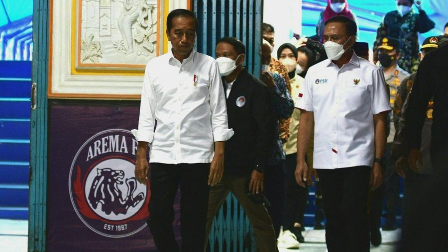 Indonesias President Joko Widodo (C) and Indonesia's Football Association of Indonesia (PSSI) chief Mochamad Iriawan (R) visit the Kanjuruhan stadium following a stampede that killed at least 131 people, in Malang, East Java on October 5, 2022. - Widodo said on October 5 that he would order an audit of all football stadiums in the country, vowing to find the 