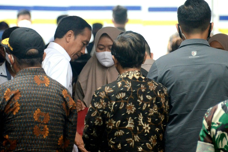 Indonesias President Joko Widodo (C) and Indonesia's Football Association of Indonesia (PSSI) chief Mochamad Iriawan (R) visit the Kanjuruhan stadium following a stampede that killed at least 131 people, in Malang, East Java on October 5, 2022. - Widodo said on October 5 that he would order an audit of all football stadiums in the country, vowing to find the 