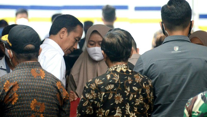 Indonesias President Joko Widodo (C) and Indonesia's Football Association of Indonesia (PSSI) chief Mochamad Iriawan (R) visit the Kanjuruhan stadium following a stampede that killed at least 131 people, in Malang, East Java on October 5, 2022. - Widodo said on October 5 that he would order an audit of all football stadiums in the country, vowing to find the 