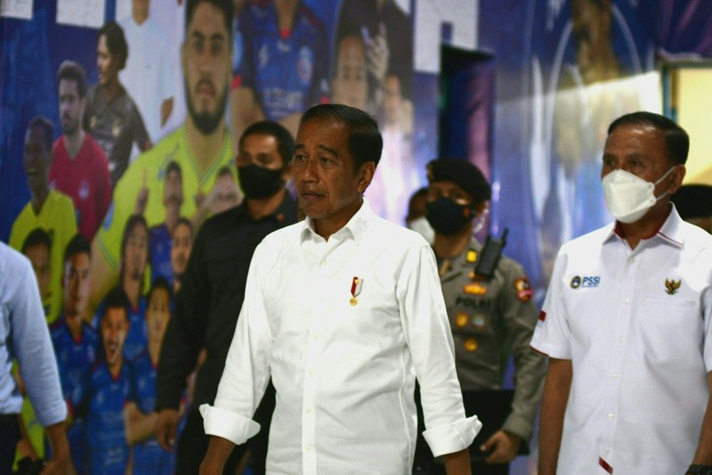 Indonesias President Joko Widodo (C) and Indonesia's Football Association of Indonesia (PSSI) chief Mochamad Iriawan (R) visit the Kanjuruhan stadium following a stampede that killed at least 131 people, in Malang, East Java on October 5, 2022. - Widodo said on October 5 that he would order an audit of all football stadiums in the country, vowing to find the 