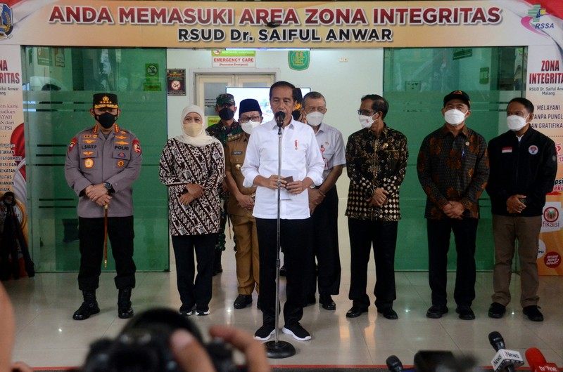 Indonesias President Joko Widodo (C) and Indonesia's Football Association of Indonesia (PSSI) chief Mochamad Iriawan (R) visit the Kanjuruhan stadium following a stampede that killed at least 131 people, in Malang, East Java on October 5, 2022. - Widodo said on October 5 that he would order an audit of all football stadiums in the country, vowing to find the 