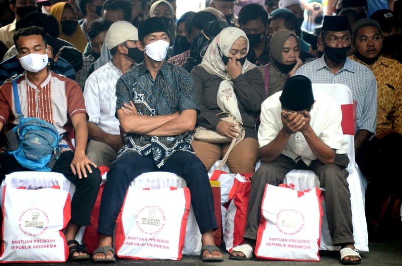 1243736755 Indonesias President Joko Widodo (C) and Indonesia's Football Association of Indonesia (PSSI) chief Mochamad Iriawan (R) visit the Kanjuruhan stadium following a stampede that killed at least 131 people, in Malang, East Java on October 5, 2022. - Widodo said on October 5 that he would order an audit of all football stadiums in the country, vowing to find the