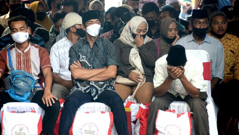 Indonesias President Joko Widodo (C) and Indonesia's Football Association of Indonesia (PSSI) chief Mochamad Iriawan (R) visit the Kanjuruhan stadium following a stampede that killed at least 131 people, in Malang, East Java on October 5, 2022. - Widodo said on October 5 that he would order an audit of all football stadiums in the country, vowing to find the 