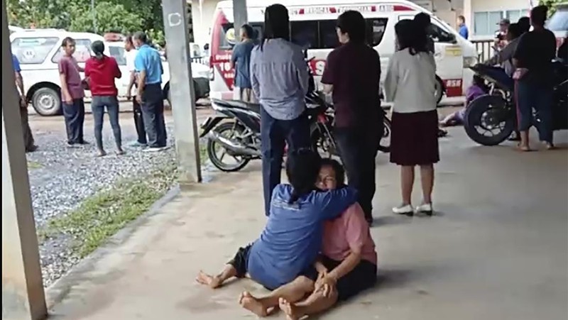In this image taken from video, officials enter the site of an attack at a daycare canter, Thursday, Oct. 6, 2022, in the town of Nongbua Lamphu, north eastern Thailand. More than 30 people, primarily children, were killed Thursday when a gunman opened fire the childcare center authorities said. (TPBS via AP)