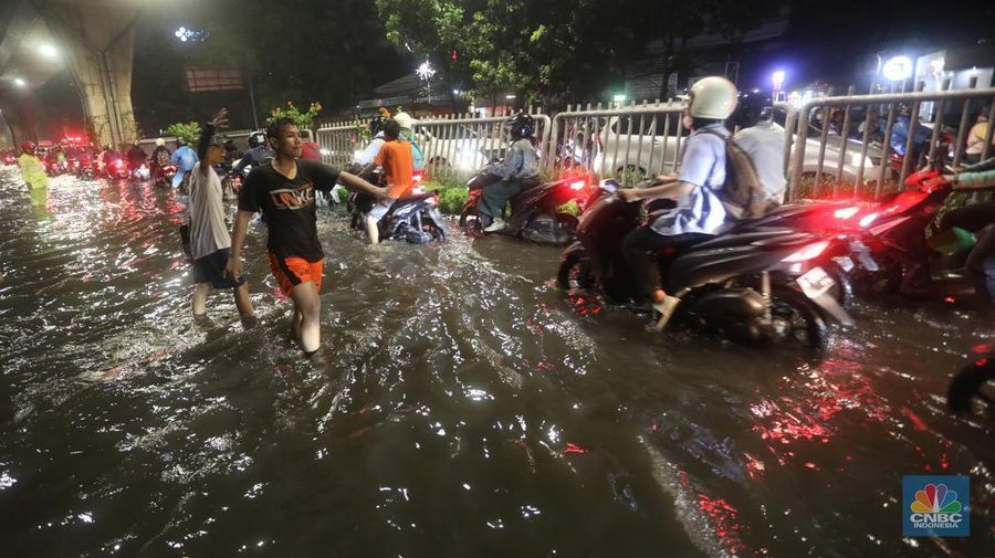 Mobil melintasi banjir di kawasan Kapt. Tendean Jakarta Selatan, Kamis (6/10/2022). Banjir yang terjadi akibat curah hujan tinggi serta drainase yang buruk membuat kawasan tersebut tergenang banjir. (CNBC Indonesia/Andrean Kristianto)