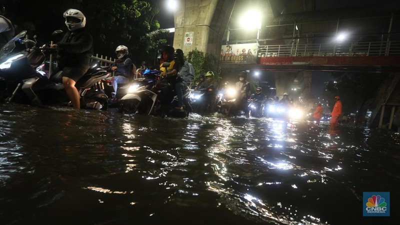 Mobil melintasi banjir di kawasan Kapt. Tendean Jakarta Selatan, Kamis (6/10/2022). Banjir yang terjadi akibat curah hujan tinggi serta drainase yang buruk membuat kawasan tersebut tergenang banjir. (CNBC Indonesia/Andrean Kristianto)