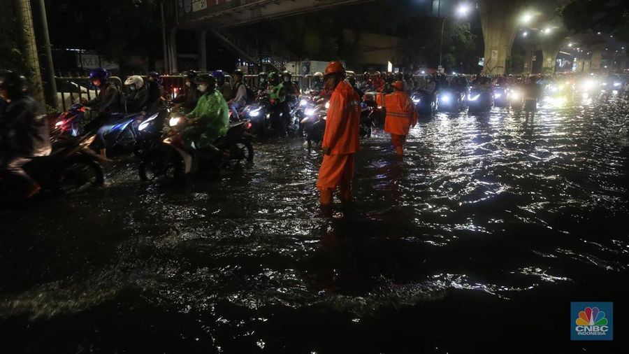 Mobil melintasi banjir di kawasan Kapt. Tendean Jakarta Selatan, Kamis (6/10/2022). Banjir yang terjadi akibat curah hujan tinggi serta drainase yang buruk membuat kawasan tersebut tergenang banjir. (CNBC Indonesia/Andrean Kristianto)