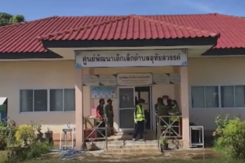 In this image taken from video, officials enter the site of an attack at a daycare canter, Thursday, Oct. 6, 2022, in the town of Nongbua Lamphu, north eastern Thailand. More than 30 people, primarily children, were killed Thursday when a gunman opened fire the childcare center authorities said. (TPBS via AP)